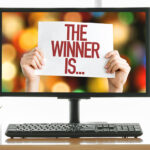 Computer monitor with the words "The Winner Is..." to showcase the winner of the computer monitor giveaway.