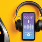 Mobile device with headphones wrapped around it, playing a podcast.